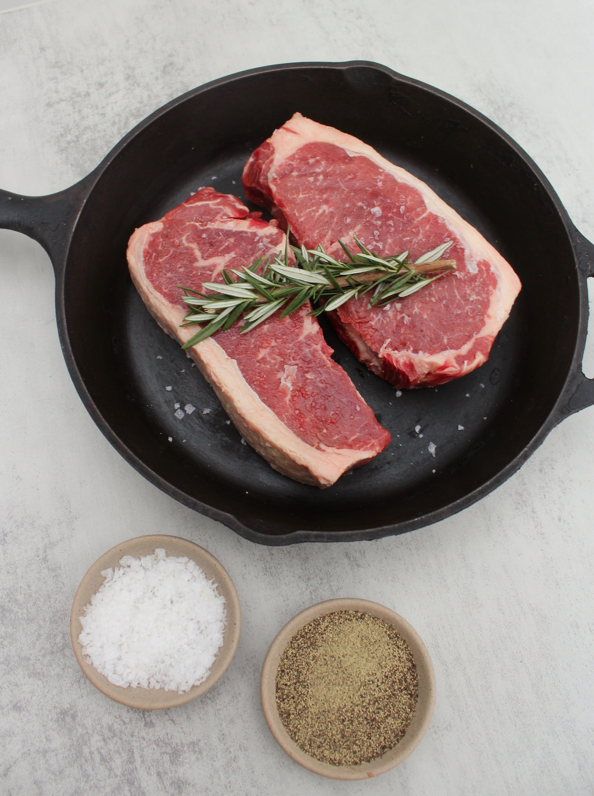 Pastured Beef, Prime New York Strip in Cast Iron with Salt, Pepper, and Rosemary